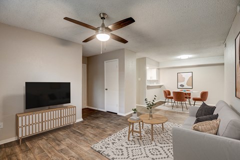 an open living room and dining room with a ceiling fan and a tv